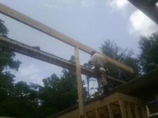Carpenter setting a ridge beam over a new addition frame — Ice Dam Removal by Roofing Brothers in Windsor Locks
