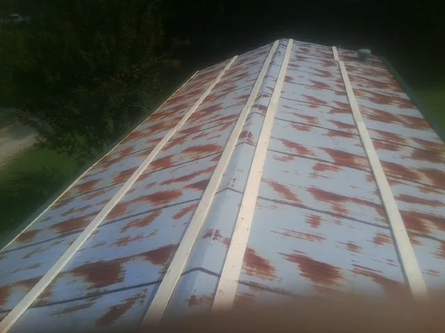 Rusted metal roof panels with new wood purlins before replacement — Storm Damage Roof Repair in Windsor Locks by Roofing Brothers