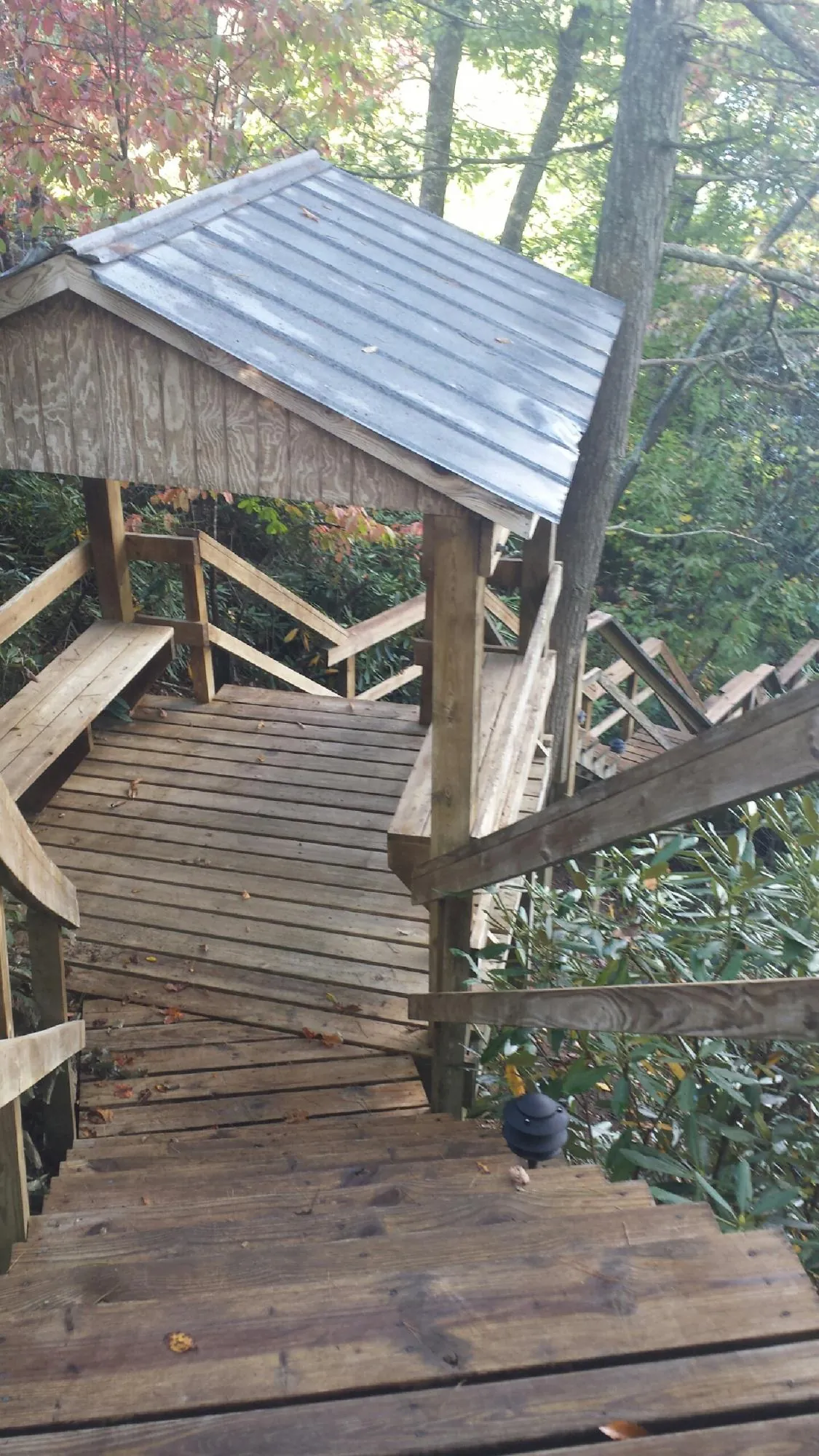 Metal roofed shelter over wooden steps on a wooded walkway — Skylight Repair & Installation work by our crew in Windsor Locks